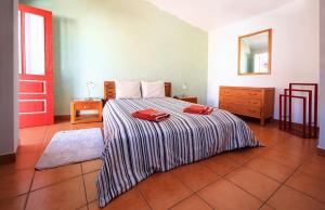 a bedroom with a bed and a red door at Casa Alentejana in Vila Nova de Milfontes