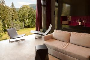 a living room with a couch and two chairs at Miura Hotel in Čeladná