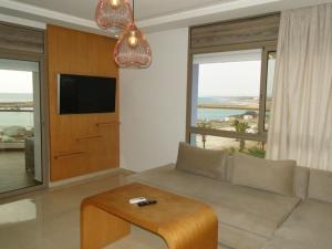 a living room with a couch and a flat screen tv at RESIDENCE PUERTO MARINA Corniche d'Asilah in Asilah