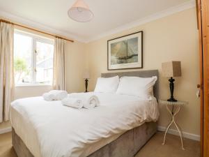 ein Schlafzimmer mit einem großen weißen Bett mit Handtüchern darauf in der Unterkunft Pugwash Cottage in Falmouth + 26 Fotos