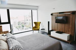 1 dormitorio con 1 cama, TV y silla en Zoes Apartment Kos Town en Cos