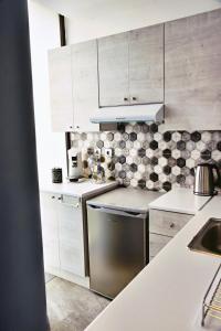 - une cuisine avec des placards blancs et un lave-vaisselle en acier inoxydable dans l'établissement Zoes Apartment Kos Town, à Kos