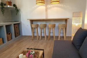 a living room with a table and stools at Patmos Little Suites in Skala