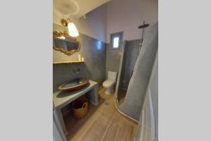 a bathroom with a shower and a sink and a toilet at Patmos Little Suites in Skala