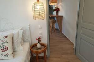 a bedroom with a bed and a table with flowers on it at Patmos Little Suites in Skala