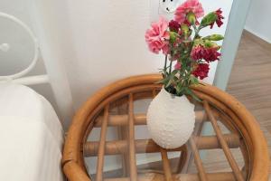 a vase of flowers sitting on top of a chair at Patmos Little Suites in Skala