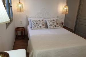 a bedroom with a white bed with pillows at Patmos Little Suites in Skala