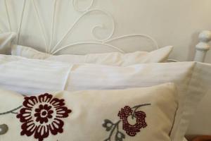 a white bed with white pillows and a white headboard at Patmos Little Suites in Skala