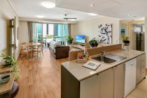 a kitchen and living room with a couch and a table at The Harbour View Condo in Cairns