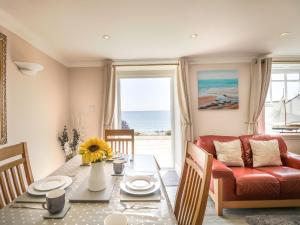 uma sala de estar com uma mesa e um sofá vermelho em Ocean Wave em Weymouth