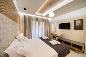 Pokój hotelowy z dużym łóżkiem i biurkiem w obiekcie Aelia Suites w mieście Áyios Pétros
