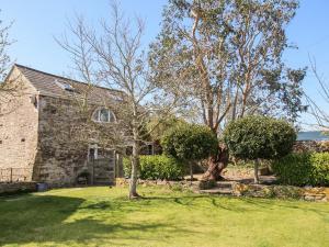 ein Steinhaus mit einem Baum im Hof in der Unterkunft Little Brook in Broadwey