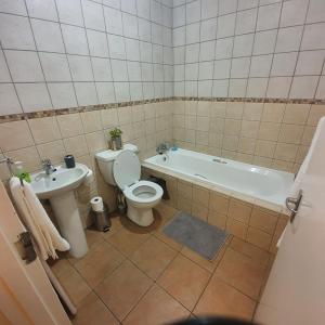 uma casa de banho com uma banheira, um WC e um lavatório. em Cosy, stylish, 2 bed apartment, free wifi, Netflix, dstv now em Midrand