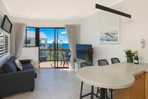 een keuken en woonkamer met een tafel en stoelen bij Ocean Boulevard in Alexandra Headland