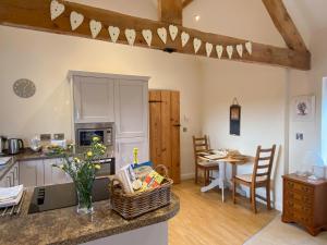 a kitchen and living room with a table and a counter at The Byre in East Cowton