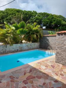 a swimming pool in a yard with a stone wall at KAZLETANG in Le Poteau