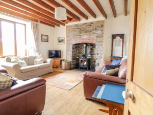 uma sala de estar com sofás e uma lareira de pedra em Groes Lwyd em Gwyddelwern
