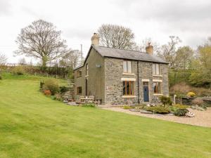 una casa de piedra con un jardín delante de ella en Groes Lwyd, en Gwyddelwern