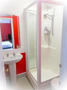 a bathroom with a shower and a sink at Rosemead Guest House in Claygate