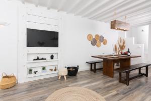 a dining room with a table and a tv on a wall at Whitelist Loft in Mykonos Town in Megali Ammos