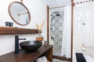 a bathroom with a black bowl sink on a wooden counter at Whitelist Loft in Mykonos Town in Megali Ammos