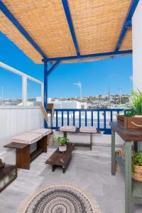 un patio con panche e tavoli sul tetto di Whitelist Loft in Mykonos Town a Megali Ammos
