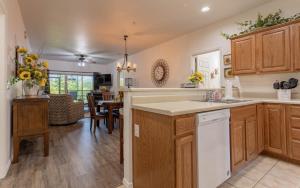 a kitchen with wooden cabinets and a dining room at Simple Serenity condo in Branson West