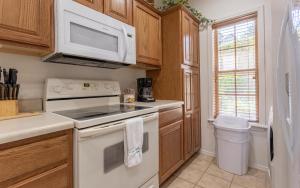 a kitchen with a stove and a microwave at Simple Serenity condo in Branson West