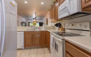 a kitchen with white appliances and wooden cabinets at Simple Serenity condo in Branson West