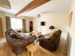 a living room with two couches and a table at The Coach House in Llanrwst