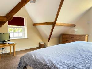 a bedroom with a bed and a desk and a window at The Coach House in Llanrwst