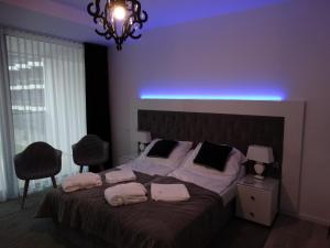 sypialnia z łóżkiem z niebieskim światłem nad nim w obiekcie Seaside apartamenty Kołobrzeg w Kołobrzegu