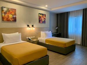 2 Betten in einem Hotelzimmer mit gelben Betten in der Unterkunft JET Hotel in Lipa