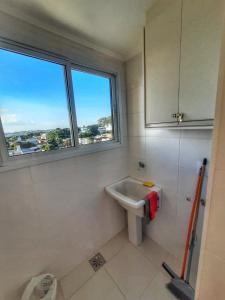 uma casa de banho com um lavatório e uma janela em BALI - PAZ & CONFORTO COM WIFI e VAGA,Máx4 pessoas em São Carlos