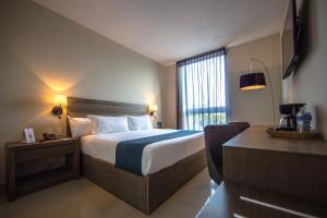 a hotel room with a bed and a window at InHouse Culiac&aacute;n in Culiac&aacute;n