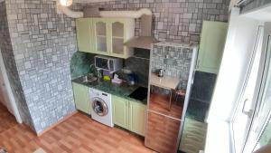 a kitchen with green cabinets and a washer at Comfortable apartment in Vladivostok in Vladivostok