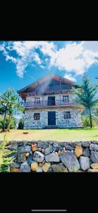 a large building behind a stone wall at Hotel Grabova in Grabova e Sipërme