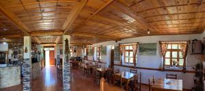 a restaurant with wooden ceilings and tables and chairs at Hotel Grabova in Grabova e Sipërme