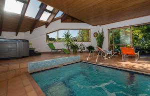 una piscina en una casa con sillas y mesa en Chalet Romantica, en Paihia