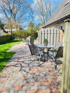 a patio with a table and chairs and a fence at Strandapartment in Westerland für 2-4 Personen in Westerland (Sylt) +19 photos