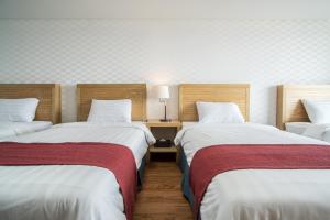 Breeze Bay Hotel في سيوجويبو: غرفة بسريرين وطاولة بها مصباح