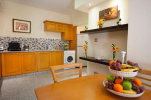 a kitchen with a table with a bowl of fruit on it at Limassol Hestia Boutique Apartment in Limassol +26 photos