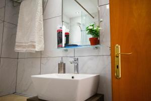 a bathroom with a white sink and a mirror at Limassol Hestia Boutique Apartment in Limassol