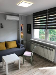 ein Wohnzimmer mit einem Sofa und einem Tisch in der Unterkunft Apartament Sikornik in Gliwice