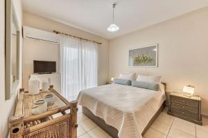 een slaapkamer met een bed en een televisie. bij Villa Ancia in Zakynthos