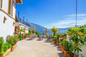 um pátio com mesas, cadeiras e vasos de plantas em Hotel Bebej Tradicional em Gjirokastër