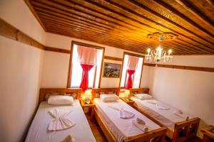 Duas camas num quarto com tecto em madeira em Hotel Bebej Tradicional em Gjirokastër