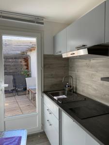 a kitchen with a sink and a patio with a table at Intérieurs-Cour in Nice