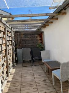 eine Terrasse mit Stühlen, einem Tisch und einer Pergola in der Unterkunft Intérieurs-Cour in Nizza