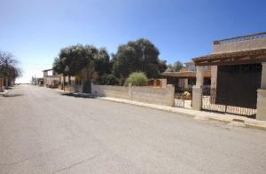 una calle vacía en un pueblo con una valla en Villa Sa Rapita Familiar en Sa Ràpita